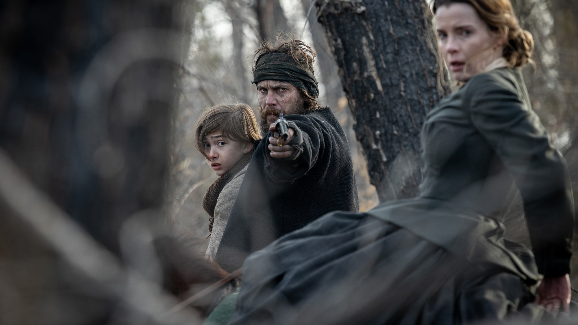 Preston Mota as Devin Rowell, Taylor Kitsch as Isaac and Betty Gilpin as Sara Rowell in American Primeval.