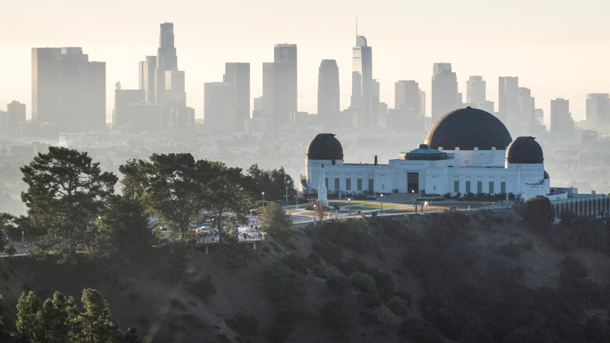 The Griffith Observatory against the downtown skyline as seen from the hiking trail at Griffith Park on Friday, Dec. 6, 2024.